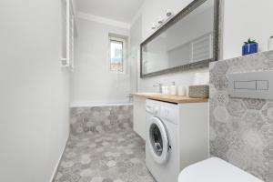 a bathroom with a washing machine and a sink at Apartments Łagiewniki Gdańsk by Renters in Gdańsk