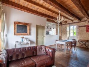 a living room with a leather couch and a table at Alluring Holiday Home in D gagnac with Heated Pool in Dégagnac