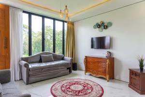 un salon avec un canapé et une télévision dans l'établissement TwoSpaces Living at deRos Resort & Cafe, Bogor, à Ciherangsating