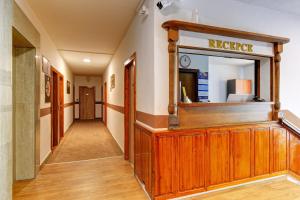 a corridor of a hallway with a mirror and a rec room at Hotel Adler in České Budějovice