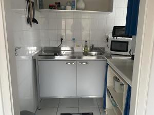 una pequeña cocina con fregadero y microondas en Bungalow, Teupitz, en Teupitz
