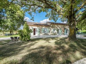 una casa de piedra con un árbol delante en Spacious Holiday Home in Saint Nexans with Terrace en Saint-Nexans