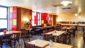 a restaurant with wooden tables and chairs and a bar at Holiday Inn Mexico Santa Fe by IHG in Mexico City