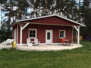 a red house with chairs and a table in front of it at Holiday home Elster-Swedenhaus 