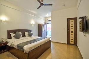 een slaapkamer met een groot bed en een plafondventilator bij Baga Treasures in Goa