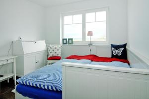 a white bedroom with a bed and a window at Semi detached house Ostseeresort Olpenitz in Kappeln