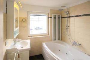 a bathroom with a tub and a sink and a bath tub at Semi detached house Ostseeresort Olpenitz in Kappeln