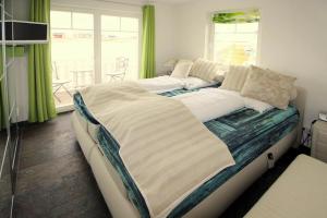 a large bed in a room with green curtains at Semi detached house Ostseeresort Olpenitz in Kappeln