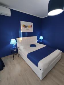 ein Schlafzimmer mit einem weißen Bett und blauen Wänden in der Unterkunft The 6th Floor in Rom