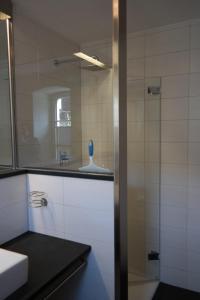 a bathroom with a glass shower and a sink at Ferienwohnung Christine in Strullendorf
