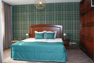 ein Schlafzimmer mit einem großen Bett mit blauen Kissen in der Unterkunft Hotel Balkan in Plewen