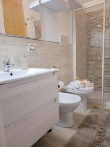 La salle de bains est pourvue d'un lavabo blanc et de toilettes. dans l'établissement JEY STUDIO_INDEPENDENT SEAFRONT APARTMENT, à Terrasini