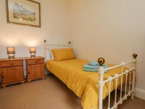 a bedroom with a bed and two night stands at Bousdale Cottage in Guisborough
