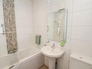 a white bathroom with a sink and a bath tub at Bousdale Cottage in Guisborough +32 photos
