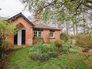 a brick house with an archway in a garden at Bousdale Cottage in Guisborough