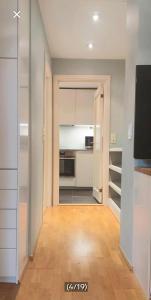 a kitchen with white cabinets and a television in a room at Casa dolce Casa apartment Oslo in Oslo