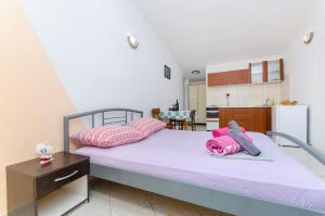 a bedroom with a large bed with pink pillows at Apartments Laguna in Stomorska +32 photos