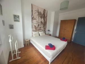 una camera da letto con un letto bianco con cuscini rossi di Chez Ca&Ro, Apt lumineux entre ville et mer a Dunkerque