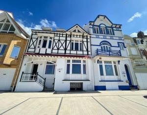 una grande casa bianca e blu con vialetto di Chez Ca&Ro, Apt lumineux entre ville et mer a Dunkerque