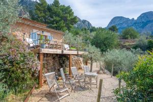 a stone building with chairs and a table in a yard at Els Abats in Sóller