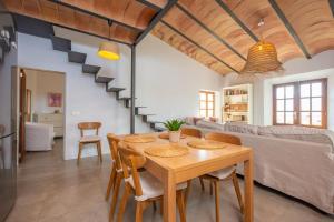 a dining room and living room with a table and chairs at Els Abats in Sóller