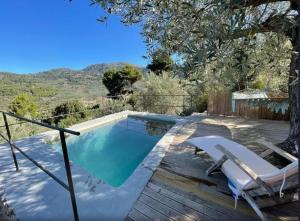 a pool with a deck and chairs next to a house at Els Abats in Sóller