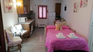 a bedroom with a bed with a pink blanket at La Casetta di Mimmi in Castel Viscardo