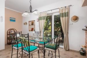 een eetkamer met een glazen tafel en stoelen bij Villa Monticello Crikvenica, 200m from sea with rome garden in Dramalj