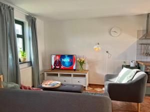 a living room with a couch and a tv at Comfortable apartment in quaint holiday village in Barlin