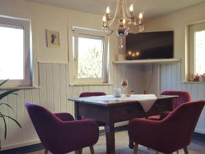 a dining room with a table and chairs and a tv at Charming holiday home with natural garden in Kaltennordheim Thuringia in Unterweid