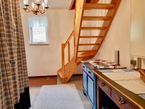 a kitchen with a staircase and a blue island at Charming holiday home with natural garden in Kaltennordheim Thuringia in Unterweid