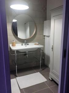 uma casa de banho com um lavatório e um espelho em Typique longère pornicaise em Pornic