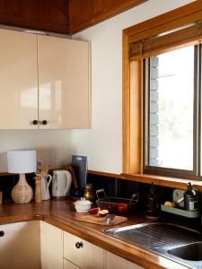 a kitchen counter with a sink and a window at Sunken Sea Shack - waterfront getaway in Eggs and Bacon Bay