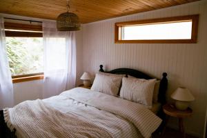 a bedroom with a large bed with a window at Sunken Sea Shack - waterfront getaway in Eggs and Bacon Bay