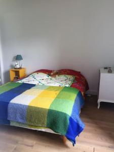uma cama com um cobertor colorido em cima em Typique longère pornicaise em Pornic