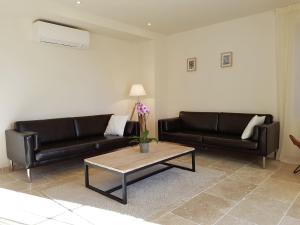Sala de estar con 2 sofás negros y mesa de centro en Classy Apartment in Villes que des Corbi res with Swimming Pool, en Villesèque-des-Corbières
