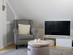 sala de estar con silla y TV en Schönhier-Vimmendorf, en Timmendorfer Strand