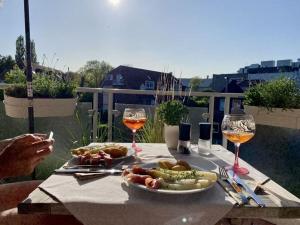 una mesa con un plato de comida y dos copas de vino en Schönhier-Vimmendorf, en Timmendorfer Strand