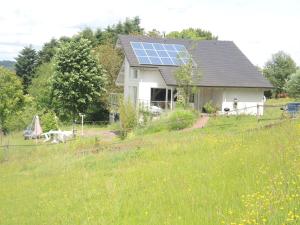 a house with a solar panel on top of a field at Holiday home with beautiful view on the village in Varsberg