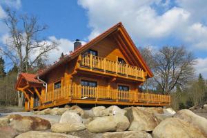ein Blockhaus mit einem großen Deck auf einem Haufen Steine in der Unterkunft Cottage Schierke in Schierke
