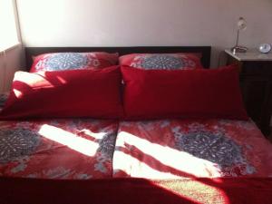 a bed with red sheets and pillows on it at Holiday apartment Old Warehouse in Münster