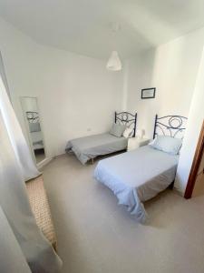 a room with two beds and a mirror in it at Mareal in La Restinga