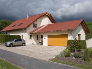 a car parked in front of a house with a garage at Holiday apartment Thoma in Königheim