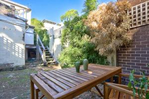 a wooden table in a garden with a cactus at Delightful 2 Bedroom House Pyrmont 2 E-Bikes Included in Sydney