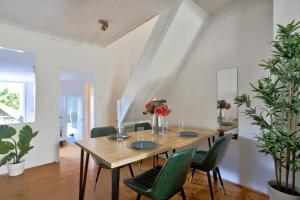 a dining room with a wooden table and green chairs at Delightful 2 Bedroom House Pyrmont 2 E-Bikes Included in Sydney