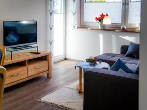 a living room with a couch and a flat screen tv at Cosy apartment in Bolsterlang in Bolsterlang