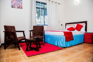 1 dormitorio con 1 cama, mesa y sillas en Family Ties, en Bagamoyo