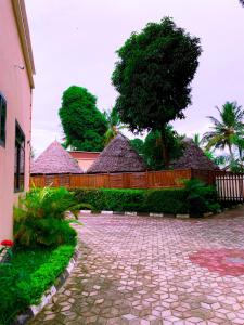 a courtyard with a fence and a tree at Family Ties in Bagamoyo