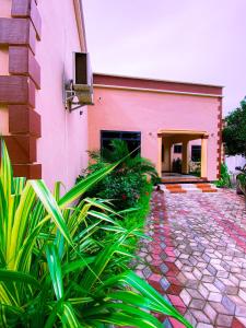 un edificio rosa con plantas delante en Family Ties en Bagamoyo