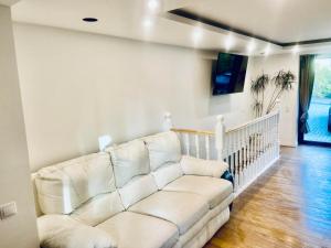 a living room with a white couch and a tv at Poilsis Nidoje -LA ISLA DE NIDA- Su terasa in Nida